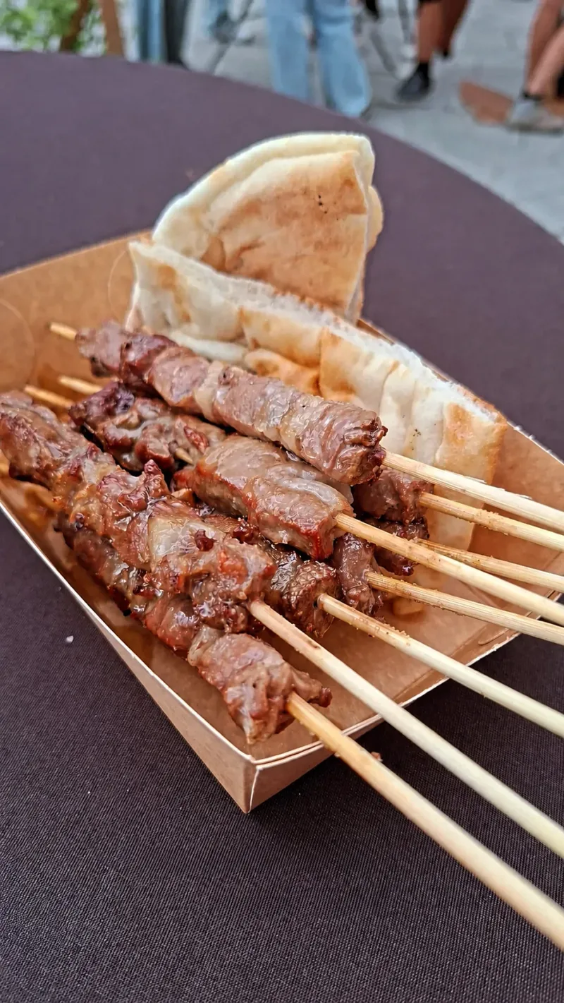 Een bakje gegrilde arrosticini met brood, op het Lachfestival